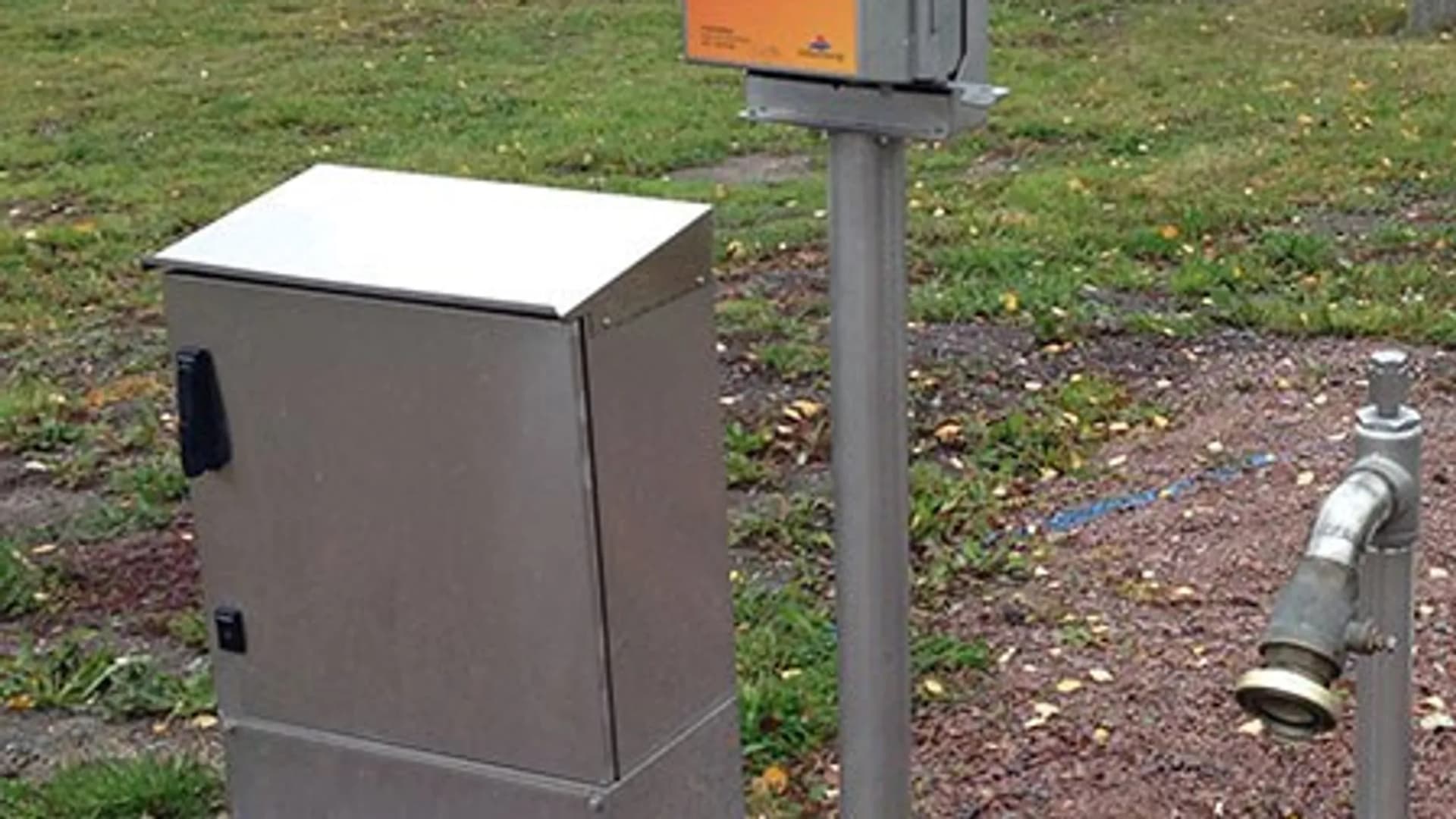 Några metallådor som står på ett fält.