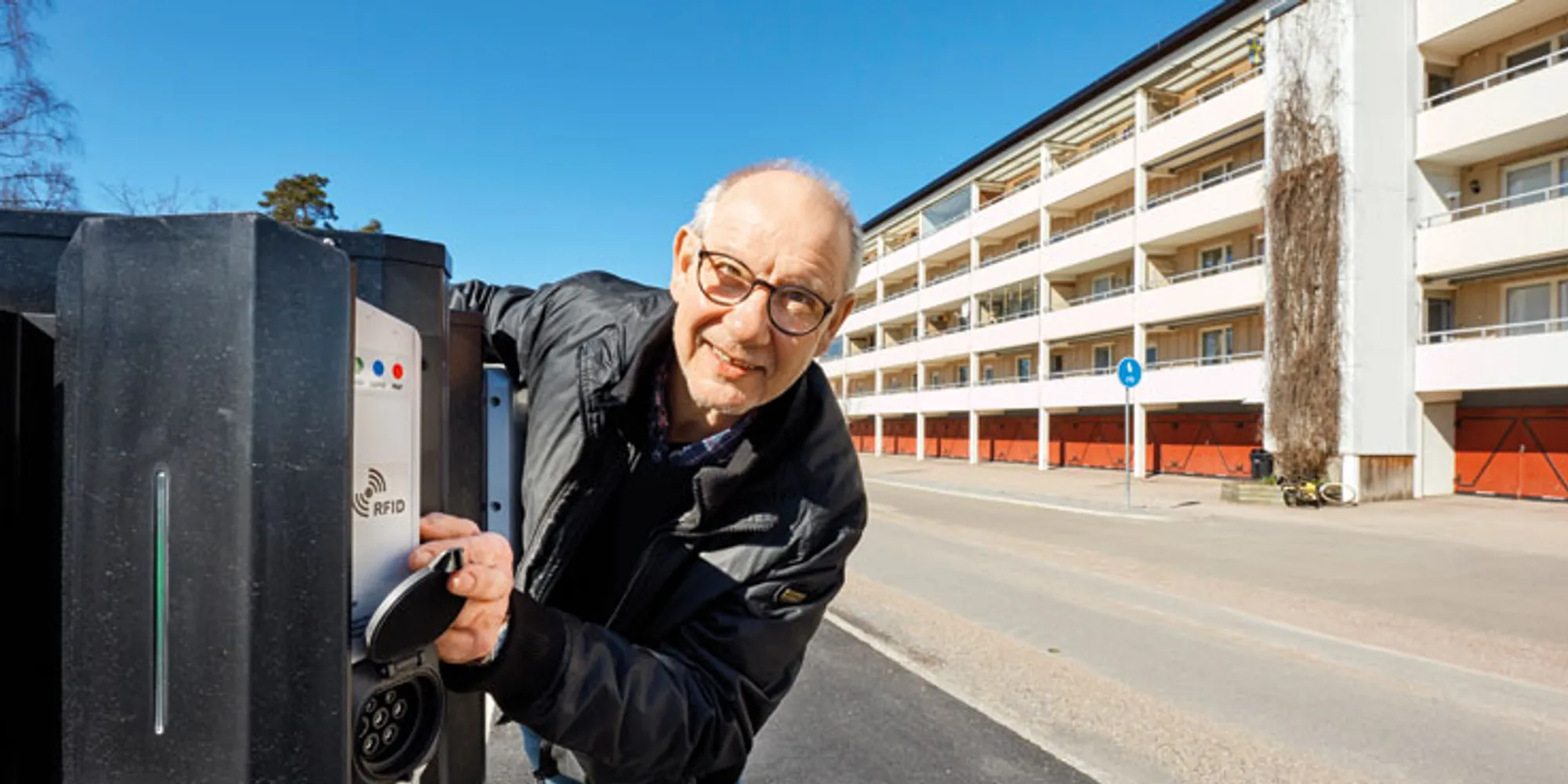En man lutar sig mot en parkeringsautomat vid sidan av vägen.