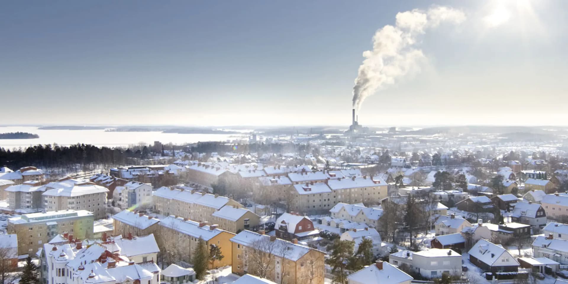En utsikt över en snöig stad med en fabrik i fjärran.