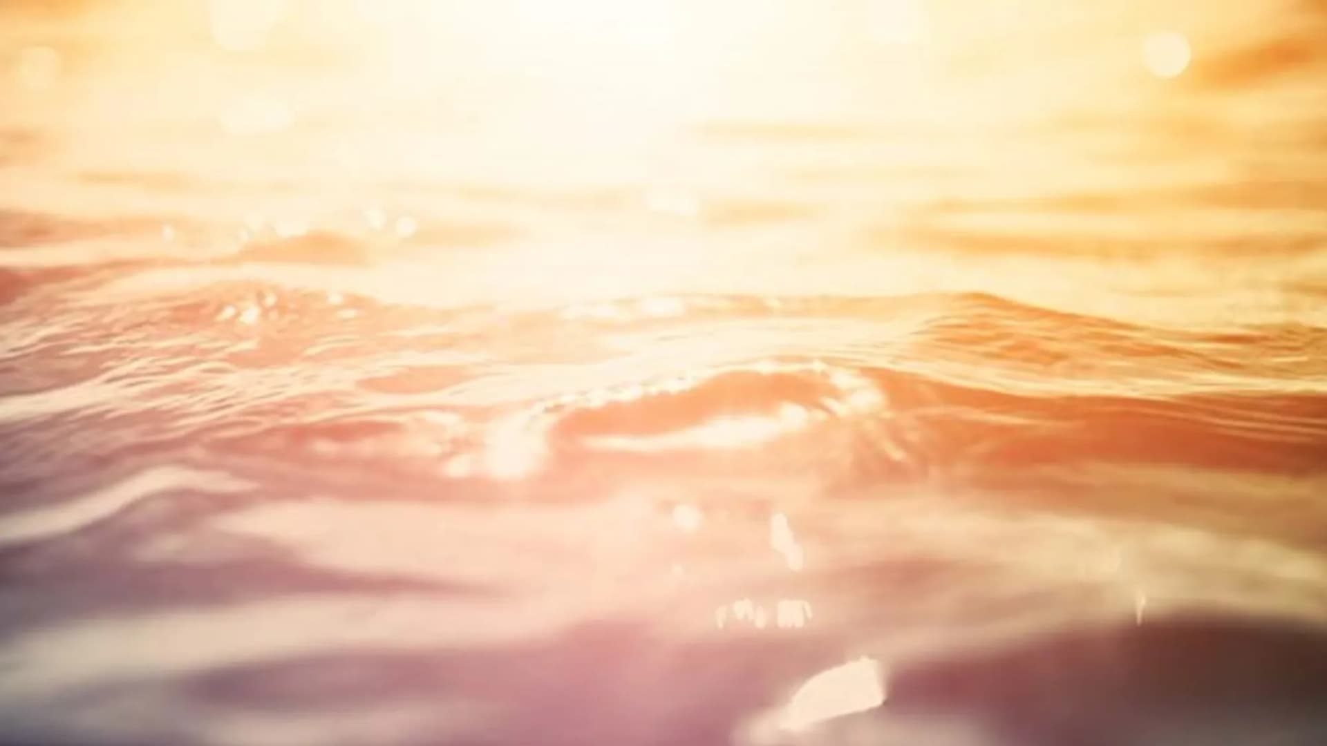 Ett suddigt foto av solen som skiner över havet.