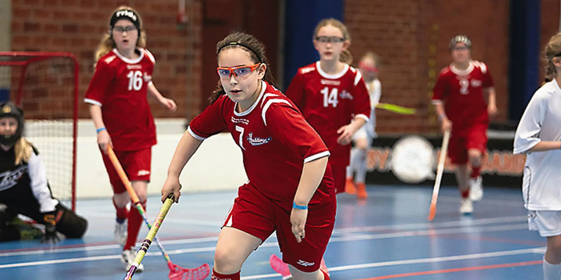En grupp tjejer som spelar innebandy.