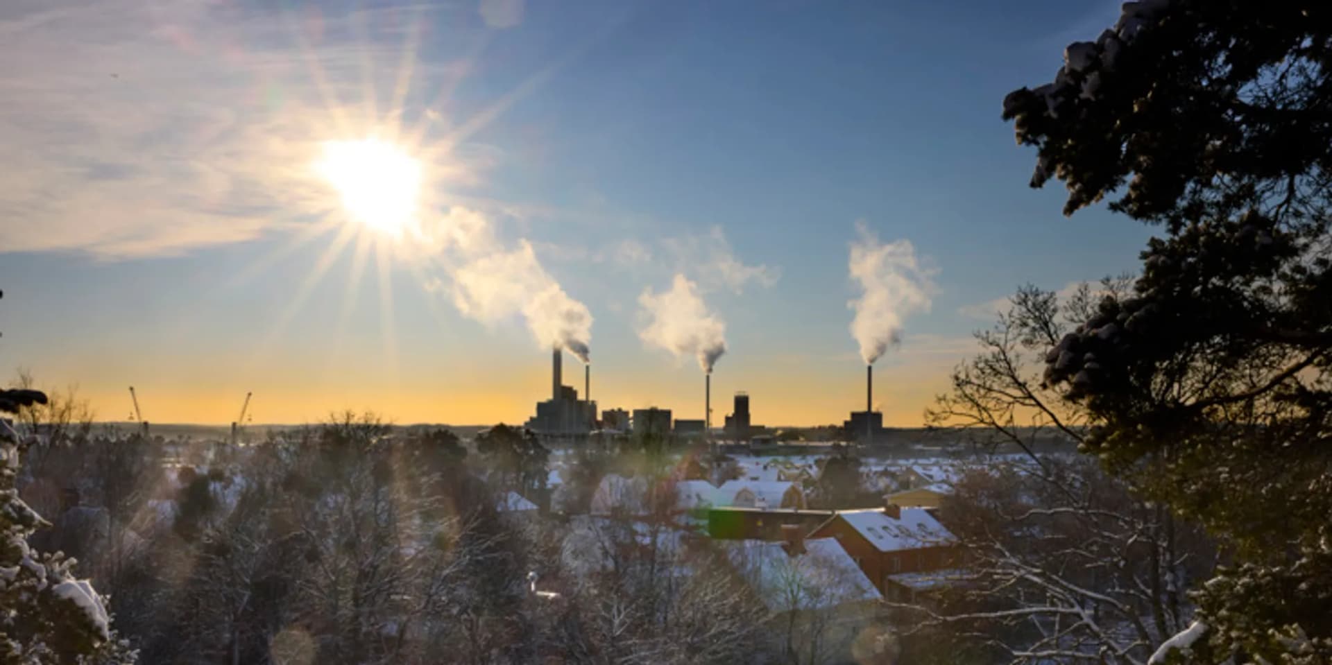 Solen skiner över en snöig stad.