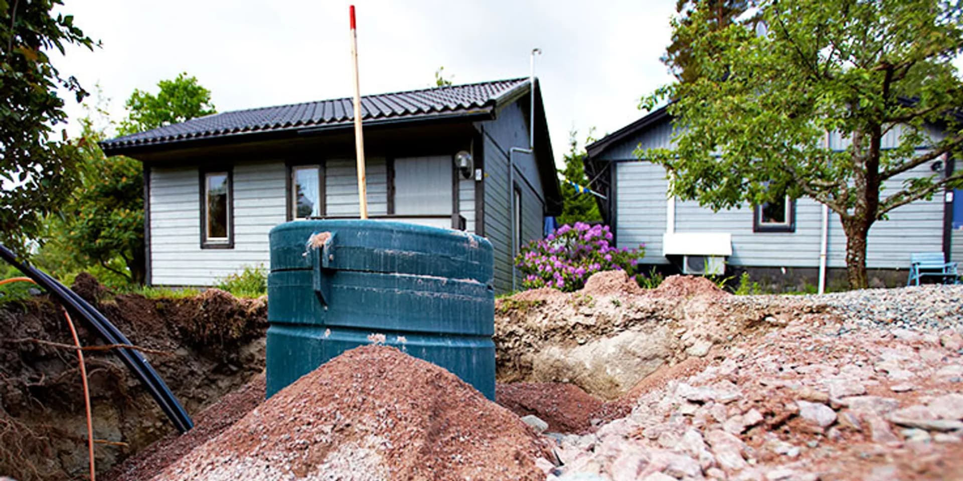 En jordhög som ligger framför ett hus.