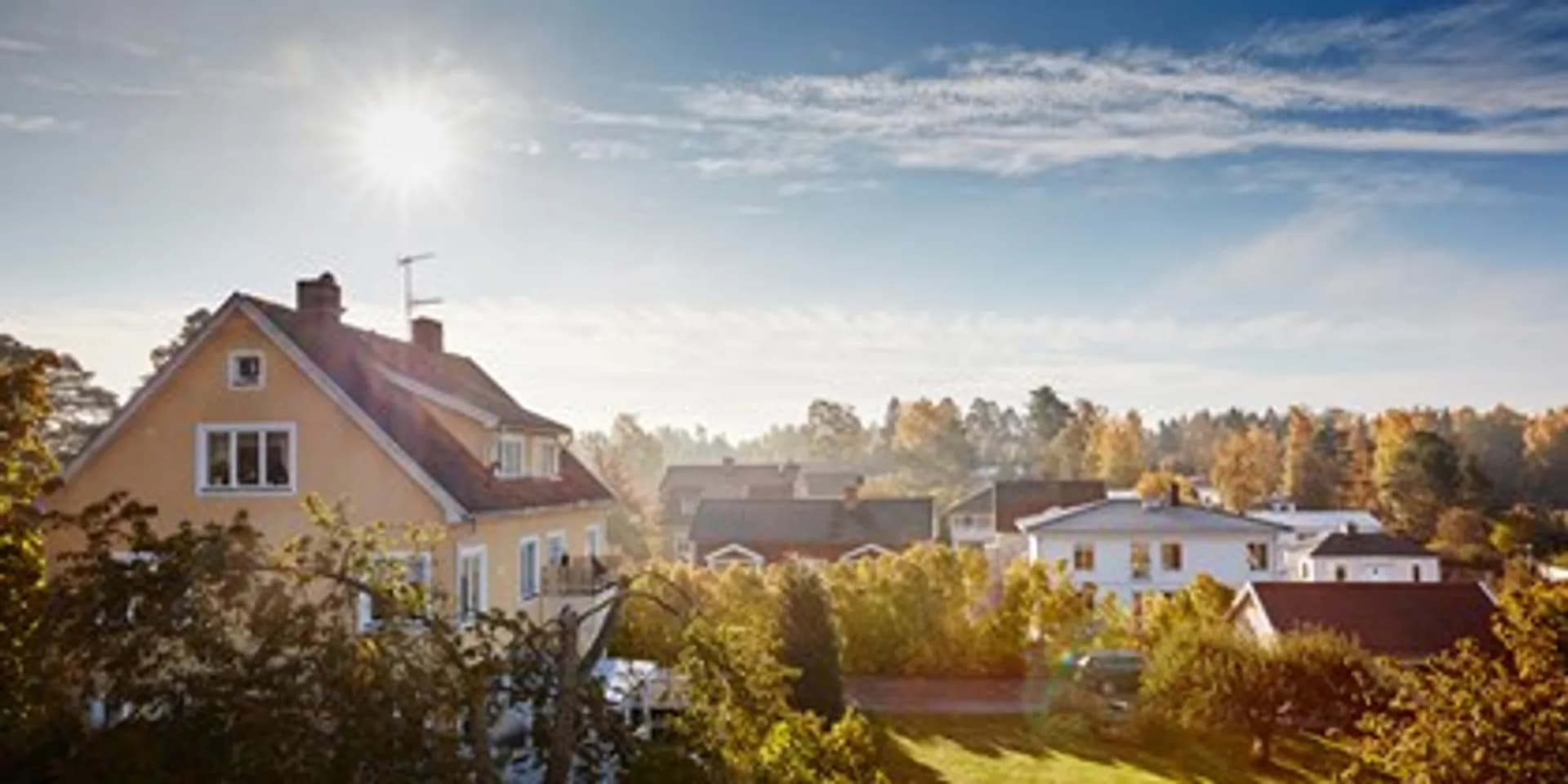 Solen skiner starkt över ett bostadsområde.