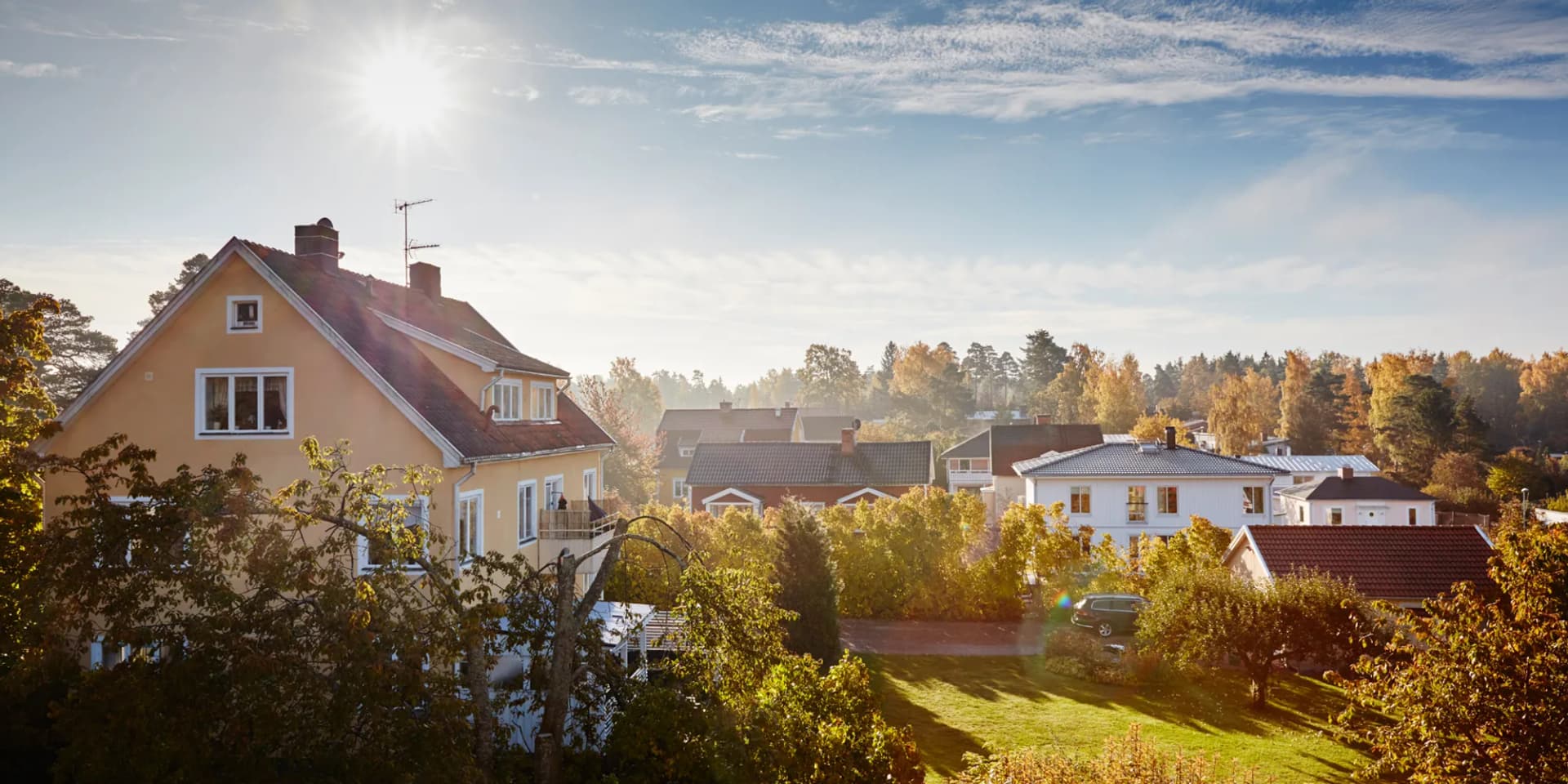 Solen skiner starkt över ett bostadsområde.