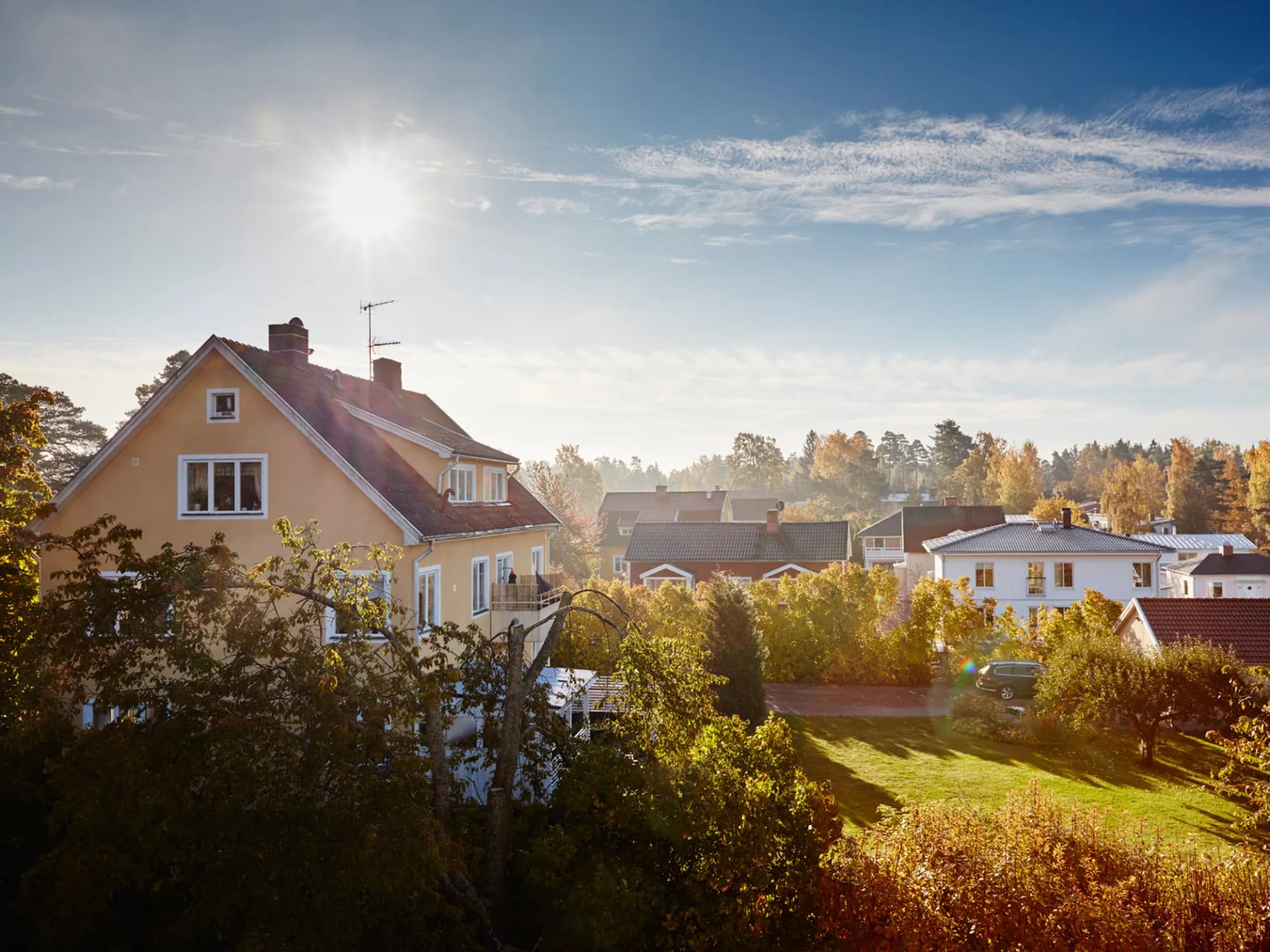 Solen skiner starkt över ett bostadsområde.