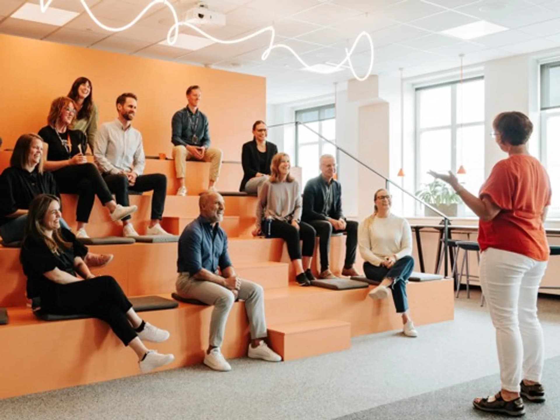 En grupp människor som sitter och står i en trappa.