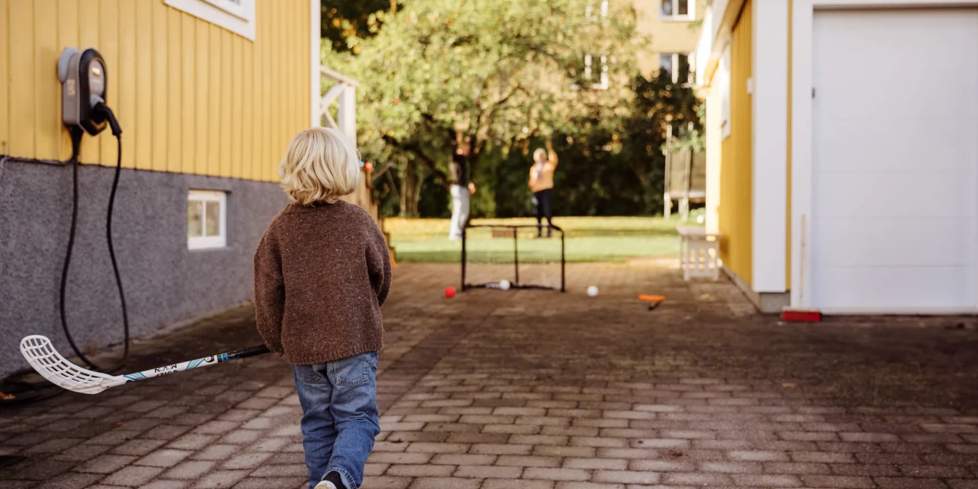 En liten pojke som går längs en tegelstensväg.