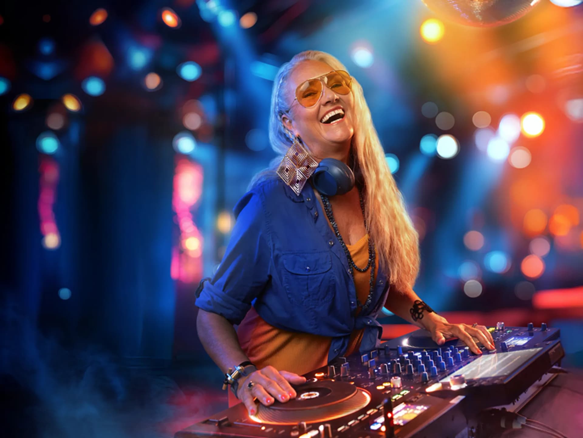 En kvinna står på en scen med en dj-mixer.