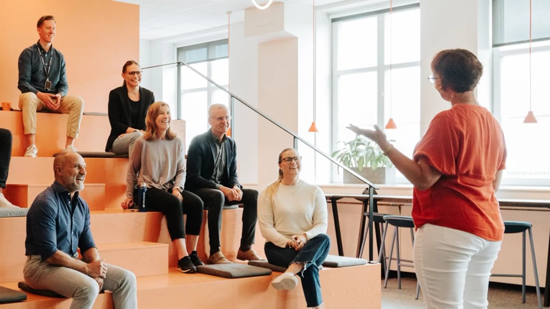 En grupp människor som sitter och står i en trappa.