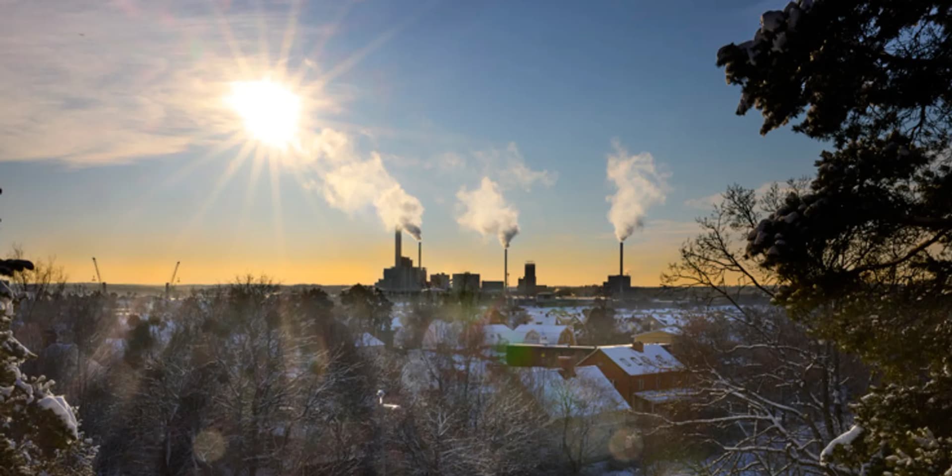 Solen skiner över en snöig stad.
