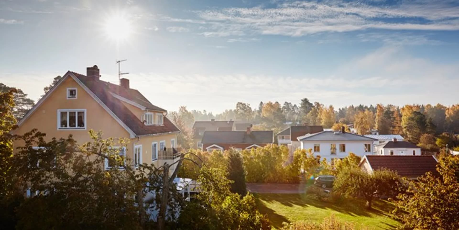 Solen skiner starkt över ett bostadsområde.
