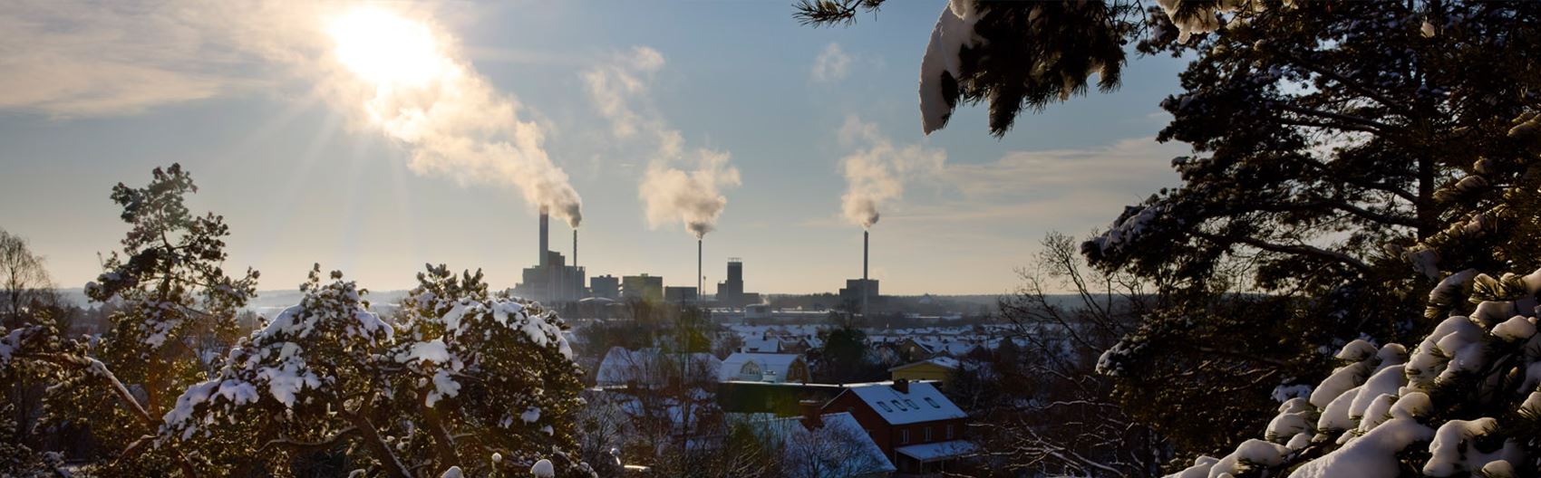 Vintrig vy över Kraftvärmeverket i västerås. Solen lyser start bakom  skorstenarna