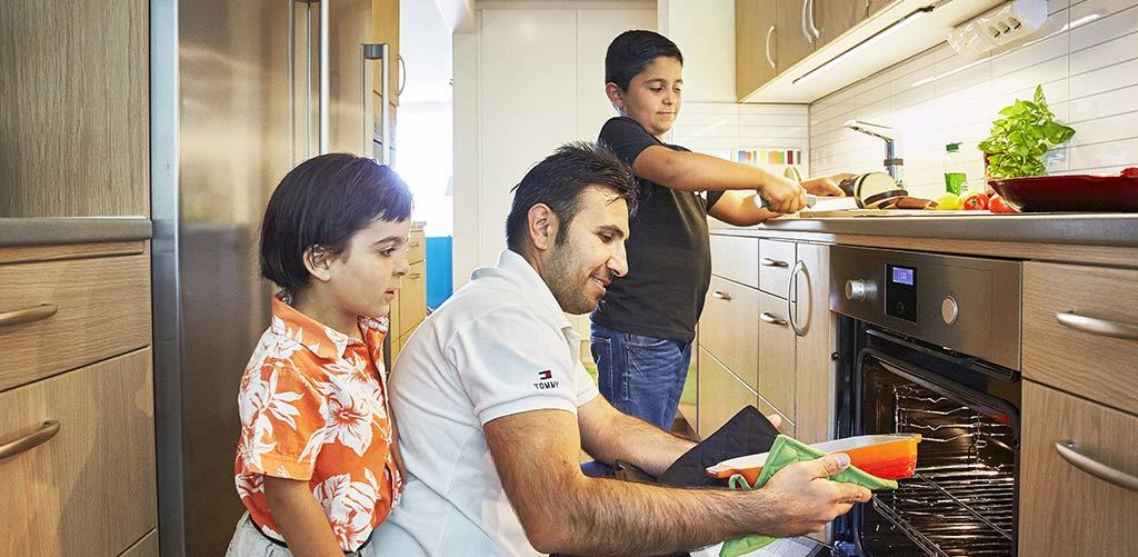 Bullar i ugnen En familj tar ut bullar ur ugnen