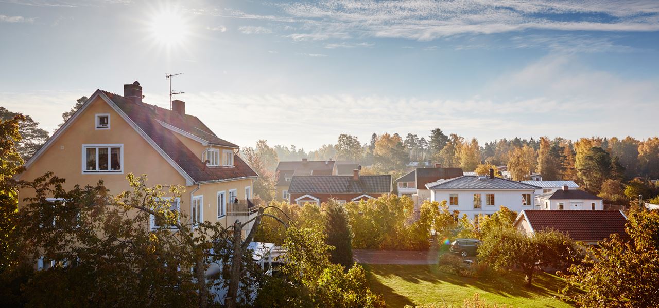 Solig dag med utsikt över hustak med solceller