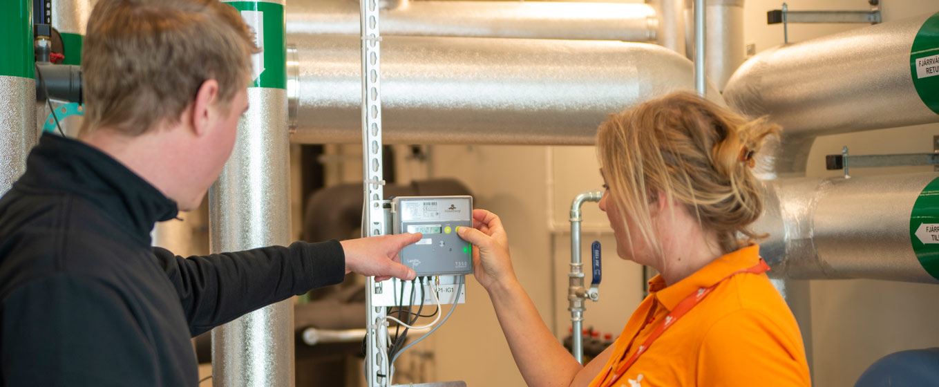 Två personer framför en mätare Två personer framför en mätare