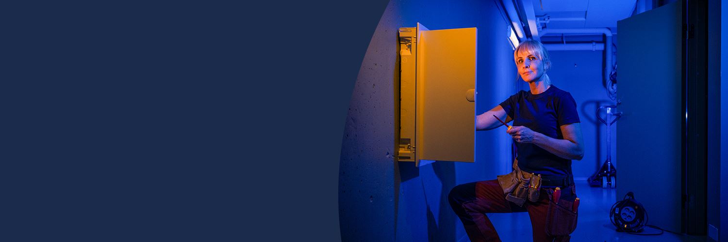 Elektriker som skruvar i elskåp.