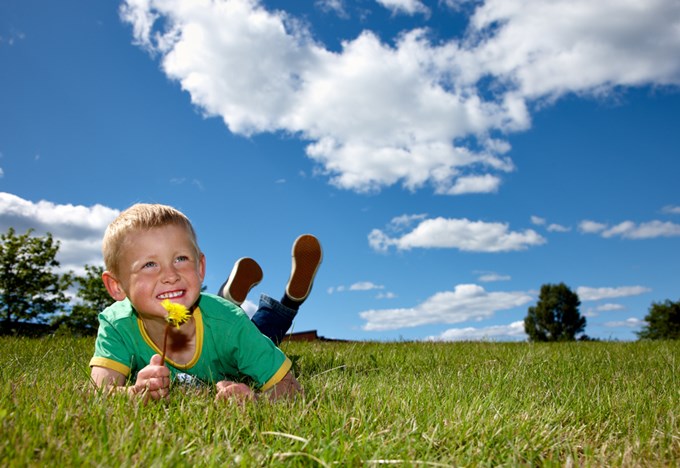 En kille ligger på gräset och njuter av solen