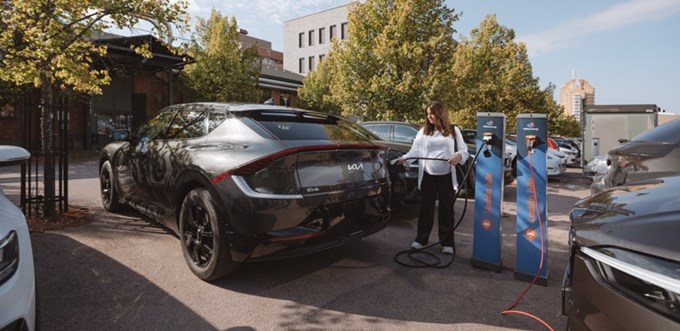 Kvinna laddar elbilen på Kopparlunden