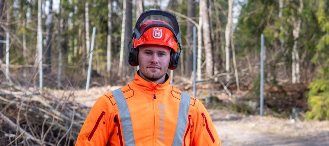 En man i orangea arbetskläder med hjälm. 