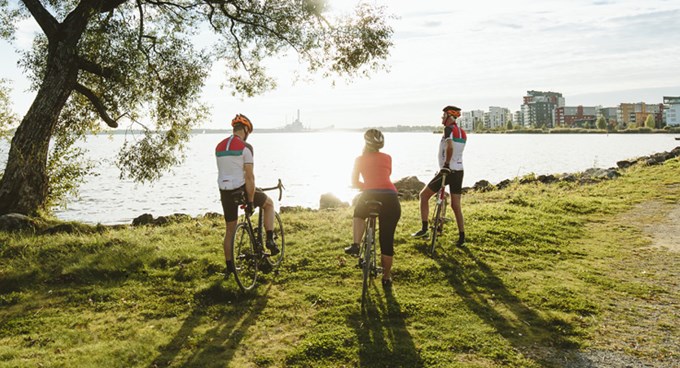 Tre cyklister ser ut över Mälaren