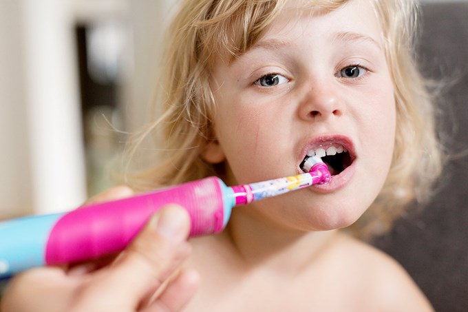 Barn borstar tänderna med eltandborste, en av många saker som behöver el