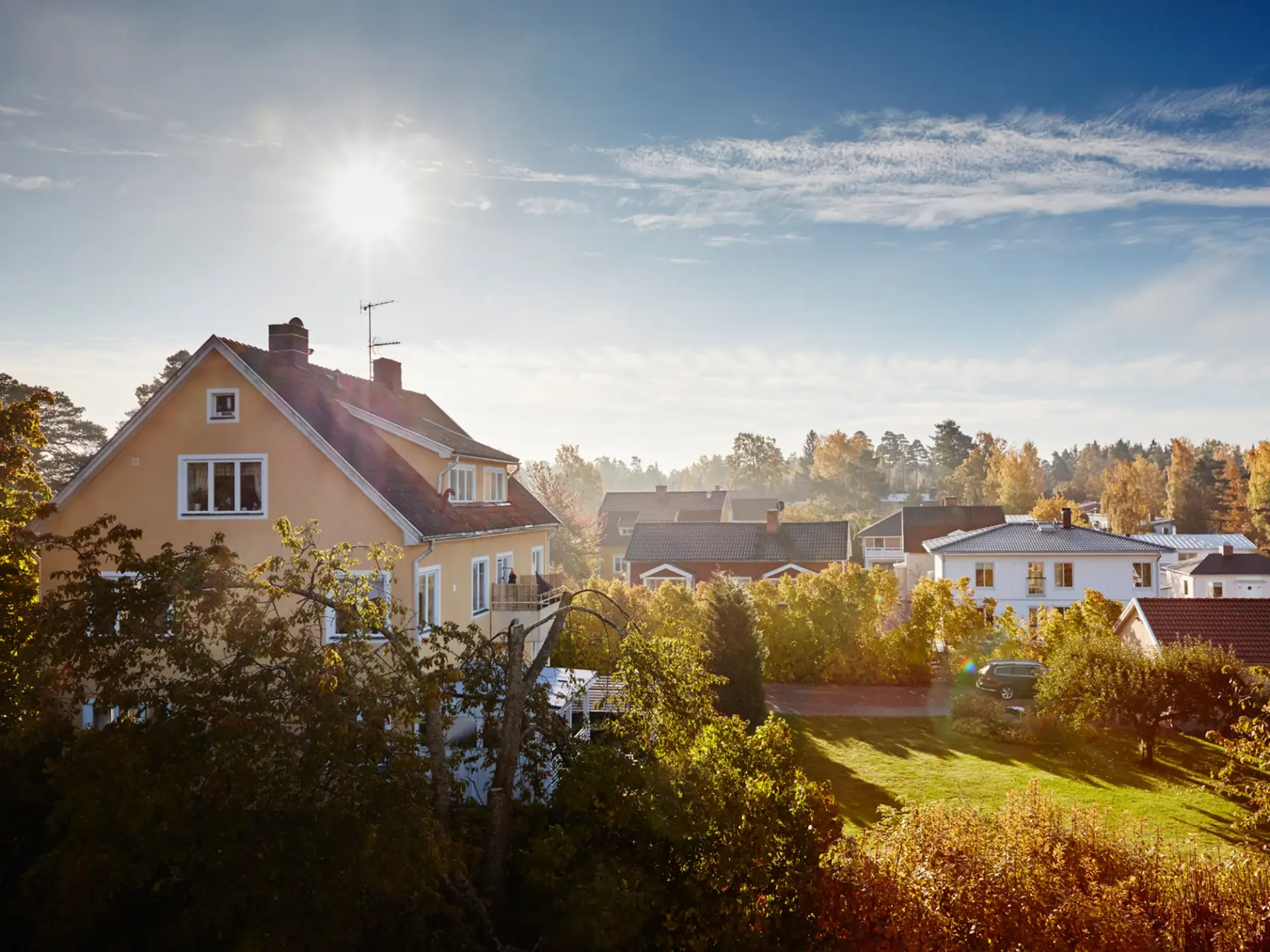 Solen skiner starkt över ett bostadsområde.